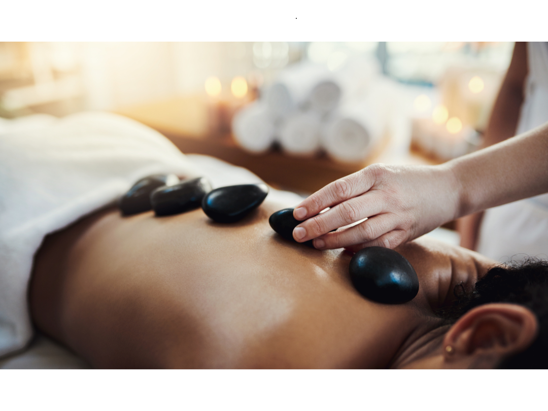 Thermal Hot Stone Massage A person receiving a stone massage with hot stones on their back.
